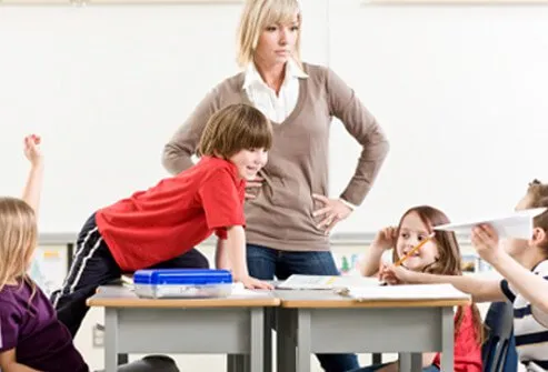 Una maestra no está contenta con la inatención de su estudiante.