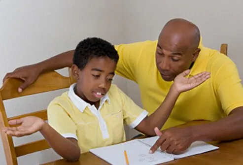 Un padre intenta ayudar a su hijo que no entiende y se está rindiendo con la tarea.